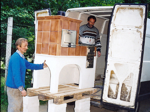 Pracovníci Jozef Mikluš a Štefan Heššo nakladajú prenosný šporák (so šiškou) ťažších rozmerov, rok 1995
