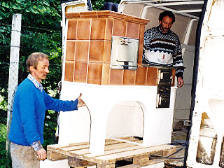 Pracovníci Jozef Mikluš a Štefan Heššo nakladajú prenosný šporák (so šiškou) ťažších rozmerov, rok 1995